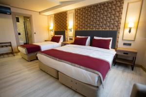 a hotel room with two beds with red pillows at Beşiktaş Serenity Hotel in Istanbul +49 photos