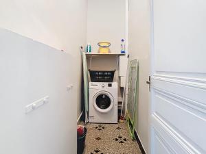 una pequeña lavandería con una lavadora. en Apartment Le Jardin, en Carcassonne