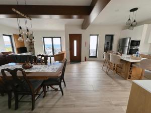 a kitchen and living room with a table and chairs at A Maresia in Feteira