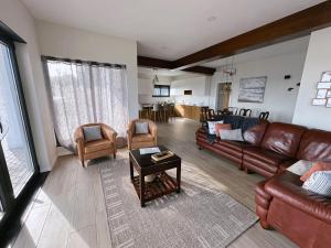 a living room with leather couches and a table at A Maresia in Feteira