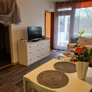 a living room with a tv on a dresser and a table at Apartment 3 312 in Goslar
