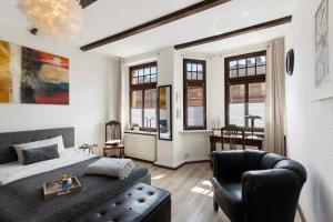 a bedroom with a bed and a couch and windows at Apartment City Leben in Nordhausen