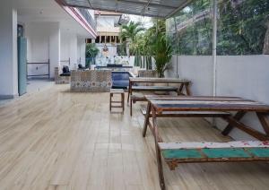an empty room with wooden tables and benches at Margarita Surf Hostel Canggu in Canggu