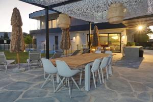 une table et des chaises en bois sur une terrasse dans l'établissement אסיה ריזורט-Asia resort, à Mishmār Hāyardin