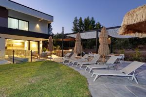 - un ensemble de chaises longues et de parasols sur la terrasse dans l'établissement אסיה ריזורט-Asia resort, à Mishmār Hāyardin