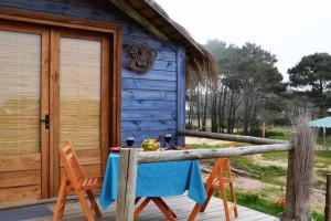 a table in front of a blue house at Arándanos in Punta Del Diablo
