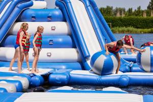 a group of people playing on an inflatable raft in the water at Holiday Suites Jabbeke - Klein Strand in Jabbeke