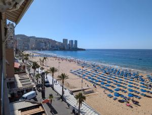 una spiaggia con sedie e ombrelloni e l'oceano di Los Gemelos - Fincas Arena a Benidorm