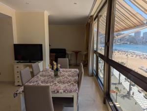 una sala da pranzo con tavolo e vista sulla spiaggia di Los Gemelos - Fincas Arena a Benidorm