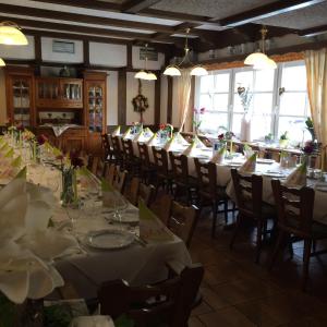Landhotel Menke في بريلون: غرفة طعام مع طاولات وكراسي طويلة بها زهور