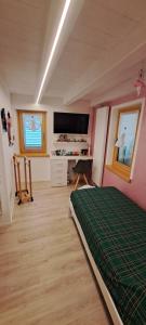 a bedroom with a bed and a desk and a tv at Chalet BORGO PRA' in Belluno