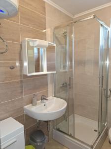 een badkamer met een wastafel en een douche bij Apartments Donadic III, Caska in Novalja +62 foto's