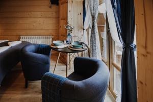 a room with two chairs and a table and a bed at Willa Nad Potokiem in Czarny Dunajec