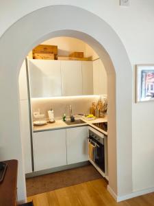 una cocina con armarios blancos y un arco en Appartamento Pagal, en Pietrasanta 4 fotos más