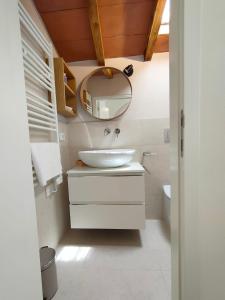 Un baño con un lavabo blanco y un espejo. en Appartamento Pagal, en Pietrasanta