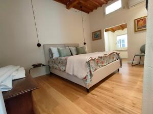 Un dormitorio con una cama y suelo de madera. en Appartamento Pagal, en Pietrasanta