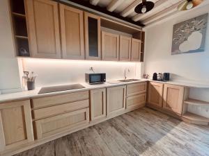 a kitchen with wooden cabinets and a sink at Bellavista La Querce in Foiano della Chiana