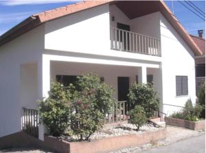 a white house with bushes in front of it at Casa do Pai II in Belmonte