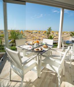 a table with a plate of food on a balcony at Hotel Nizza Frontemare Superior 3 Stelle in Lido di Jesolo