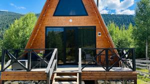 a cabin with a large glass door on a deck at Cottage and sauna hill silence mestia 2 in Mestia