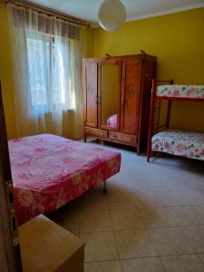 a bedroom with a bed and a cabinet and a window at Casa cascine in Pont-Saint-Martin