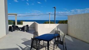 a table and chairs on a balcony with the ocean at Departamento Las Olas con terraza frente al mar in Quequén