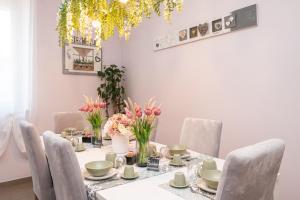a dining room with a table with chairs and flowers at La Vecchia Tenenza B&B in Città della Pieve