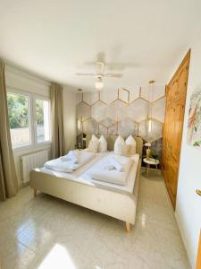 ein Schlafzimmer mit einem großen Bett und weißen Kissen in der Unterkunft Traumvilla Mimosa, Costa Blanca in Cumbre del Sol