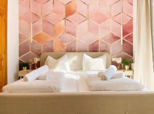 ein Bett mit zwei weißen Kissen und einer rosa Wand in der Unterkunft Traumvilla Mimosa, Costa Blanca in Cumbre del Sol