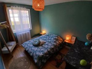 a bedroom with a bed and two candles on two tables at La maison aux volets bleus in Le Vigean