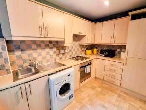 cocina con armarios blancos y lavadora en La Casita, Quarry - 2 bedroom Entire Apartment with Free Parking, en Glasgow 37 fotos más