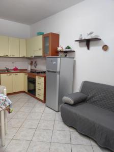 cocina con nevera y sofá en una habitación en Pula - Spiagge e Sole, en Pula