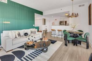 a living room with a white couch and a green wall at Penthouse Perfection With Unmatched Skyline Views in Stamford +22 photos
