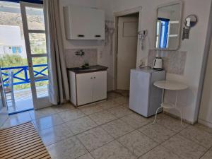 a kitchen with a refrigerator and a table in it at Katerina Yalos in Ios Chora