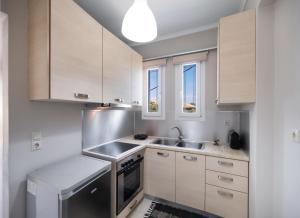 a kitchen with white cabinets and a sink at Apricus Apartments in Apolpaina +3 photos