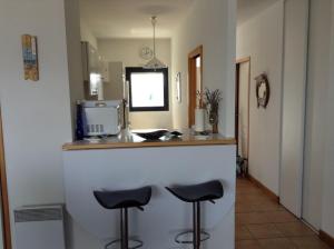 a kitchen with two stools at a counter at Les 2 tours La Rochelle in La Rochelle +7 photos