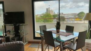 a dining room with a table and chairs and a large window at Les 2 tours La Rochelle in La Rochelle