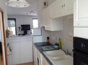 a kitchen with white cabinets and a sink at Les 2 tours La Rochelle in La Rochelle