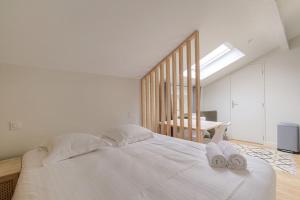 a bedroom with a white bed with towels on it at Studio cosy, climatisé, Caluire-Lyon in Caluire-et-Cuire