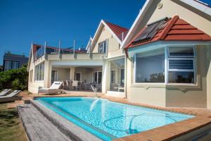 una villa con piscina frente a una casa en Solar Spark, en Knysna