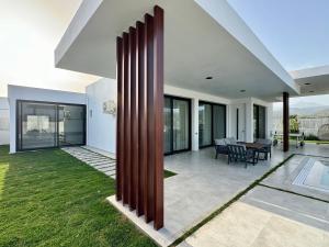 an external view of a house with large wooden columns at Ashta Suites - Nora Suite in Fethiye