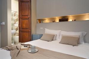 a bedroom with a large white bed with a headboard at Dimora Storica Nella Torre Bed & Breakfast in Ascoli Piceno