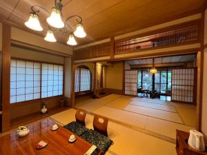 a room with a table and chairs and windows at すいこうえんさくら in Fujinomiya