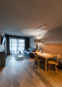 a living room with a wooden table and a couch at Sportony Mountain Lodges in La Villa