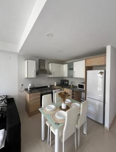 a kitchen with a table and chairs and a refrigerator at apartamento 4 in Benicarló