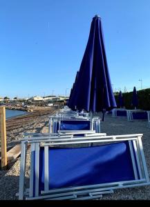 een groep tafels met parasols op een strand bij Casa SoleLuna in Santa Marinella