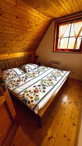 a large bed in a room with a wooden ceiling at Drevenička Amálka in Liptovský Trnovec