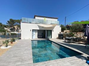 a villa with a swimming pool in front of a house at Maison avec piscine in Agay - Saint Raphael