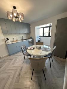 a kitchen and dining room with a table and chairs at Davinci Apartment in Sibiu