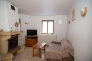 Una sala de estar con un sofá y una chimenea. en Gîte Gîtes de France 4/6 personnes à Chasseradès, en Chasseradès
